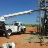 Delta team using boom truck to replace a pump jack motor.