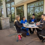 Nursing staff team members talk and eat lunch outside.