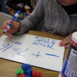 Using manipulatives for problem solving; in this case _+7=16, or 'What is under the cup?'