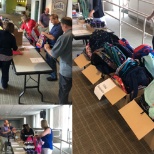 Colleagues stuffing backpacks to donate to local school communities