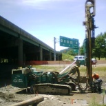 Drilling 60ft holes to make micropiles for highway foundation