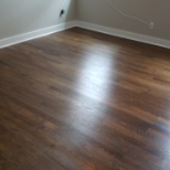 Finished hardwood flooring installed in home in a bedroom.d