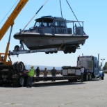 Loading harbor patrol boat onto trailer for transport.