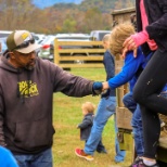 Staff member Arthur helps children off the hay ride at Bold Rock's annual Fall Foliage Festival