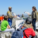 International trainees teach raptor identification to visitors gathered at the North Lookout.