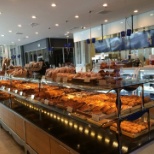 Pastry area of the store, dining area in the left side, kitchen and sales area on the right side.