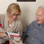 Caregiver and client reading together.