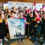 Prospects stand in front of a step-and-repeat, holding a poster for a movie.