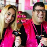 Two Prospects in pink vests smile for a photo while holding gift cards.