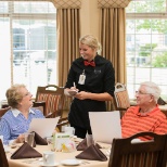 Server with residents in the dining room