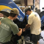 Employee explaining the process of servicing a tractor