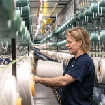 A team member setting up the yarn on the loom in our production facility in Beligum