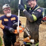 GMS employees dropping trimming line down a borehole to prepare for chemical injection. 