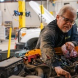 Miller Pipeline mechanic performs an engine check on a vehicle inside Miller Pipeline's shop