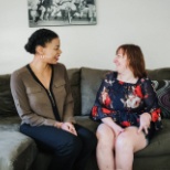 two people facing each other while sitting on couch